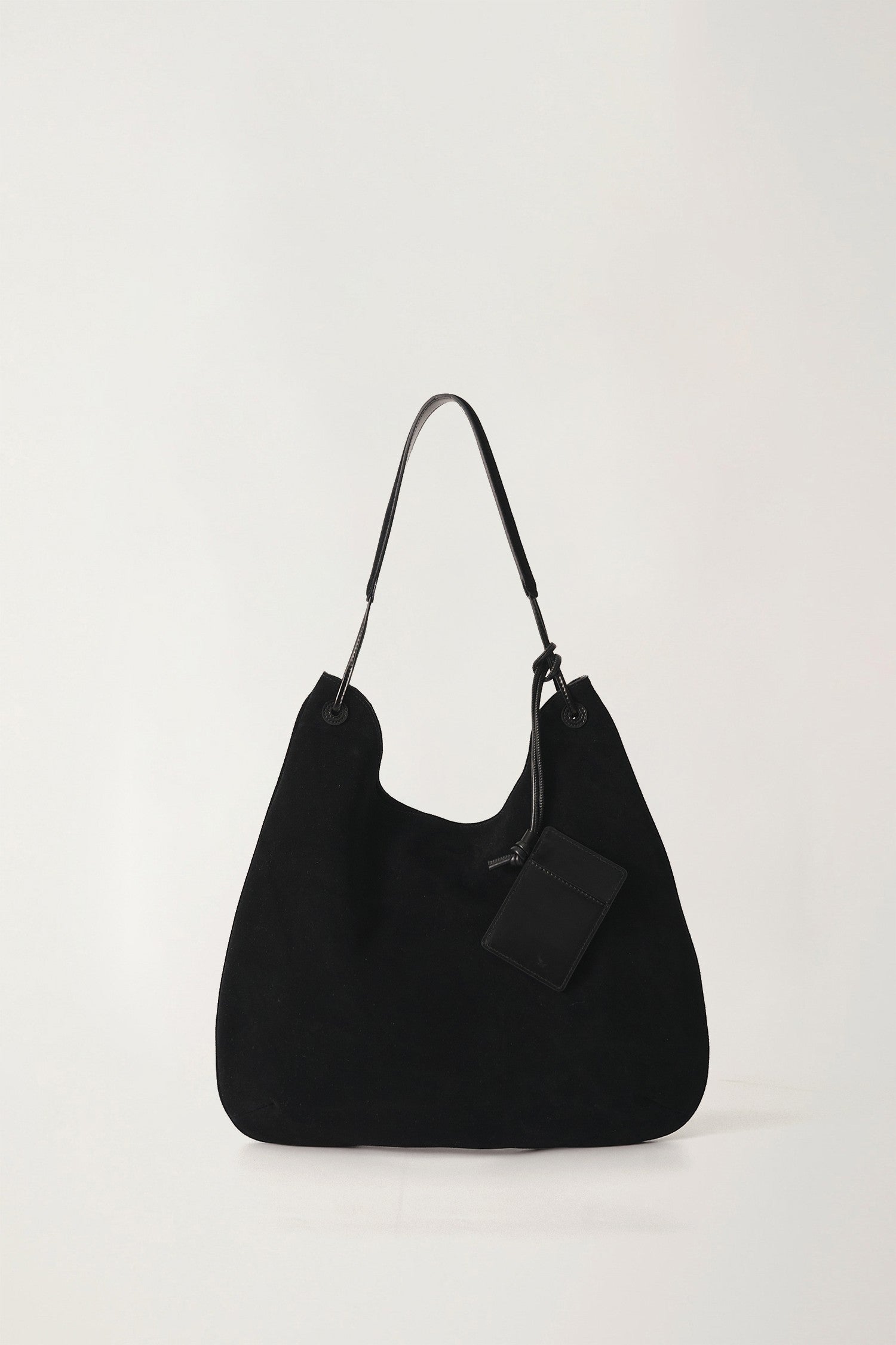 Black handbag with a tag on a white background